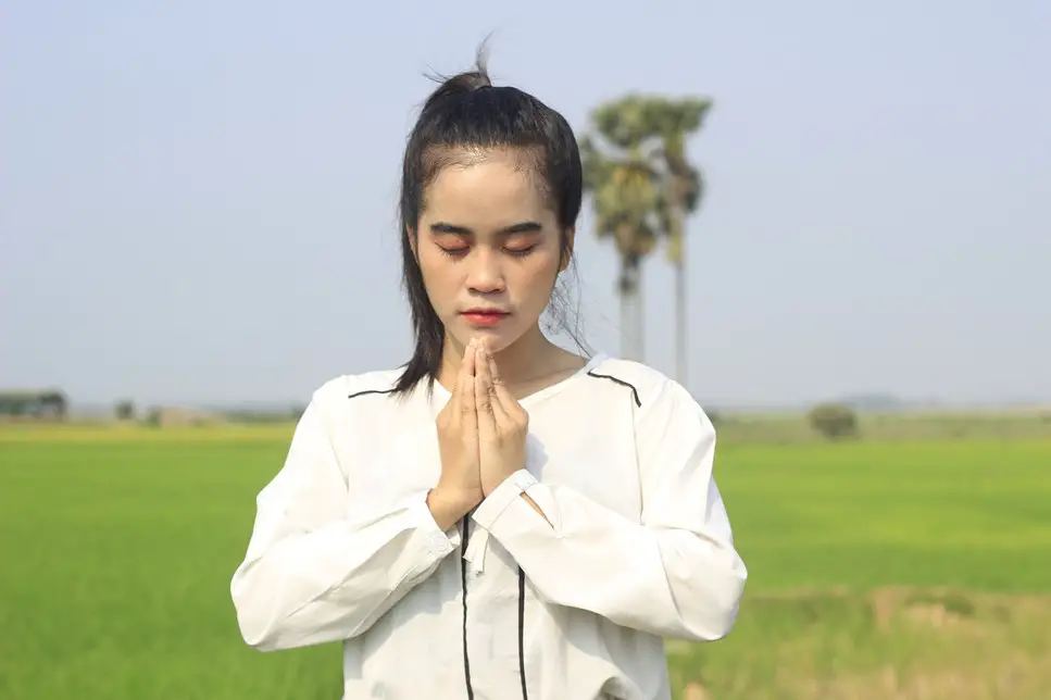 woman praying in an open field